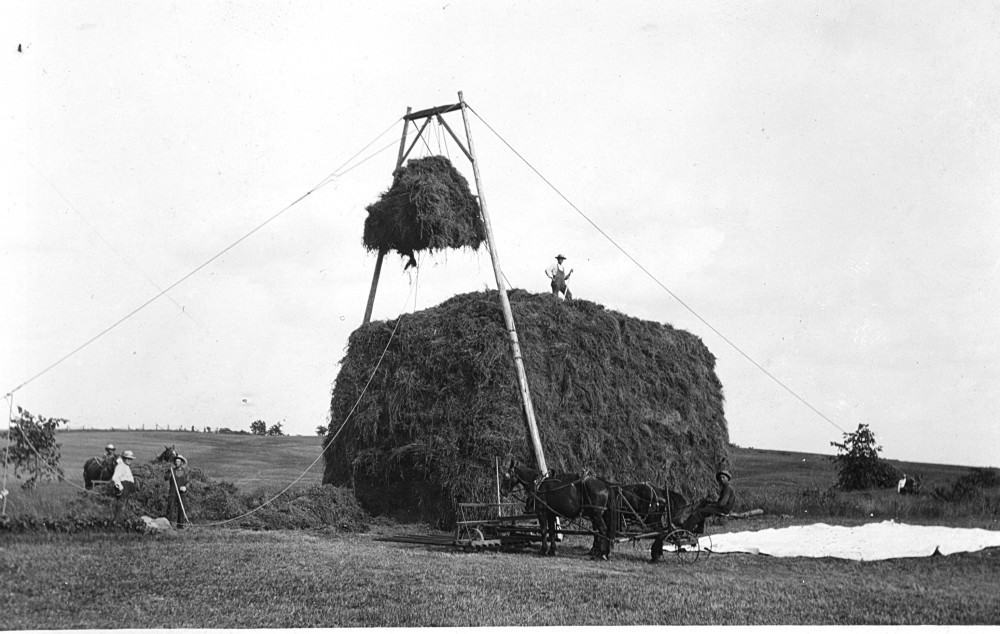 Using poles, a sling and a winch to stack hay. Cornfalfa Farms collection, New Berlin Historical Society.