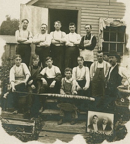 Employees pose outside of H. J. Ammann Cigar Factory with the founder's photo in the foreground, Kiel, ca. 1900. Heritage Collection, Kiel Public Library.