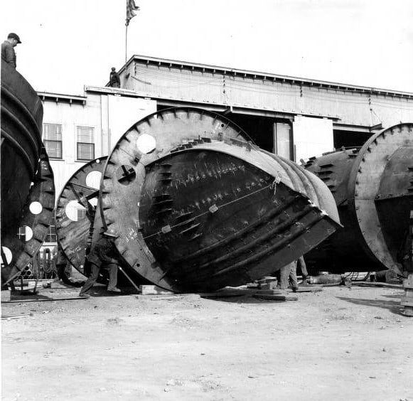 Kewaunee Shipbuilding and Engineering built tugboats as well as large cargo vessels. This image shows rings built around ship hulls in order to roll them upright after welding. According to local history, the rings were necessary because the company only had one crane available due to wartime shortages. Kewaunee Public Library.