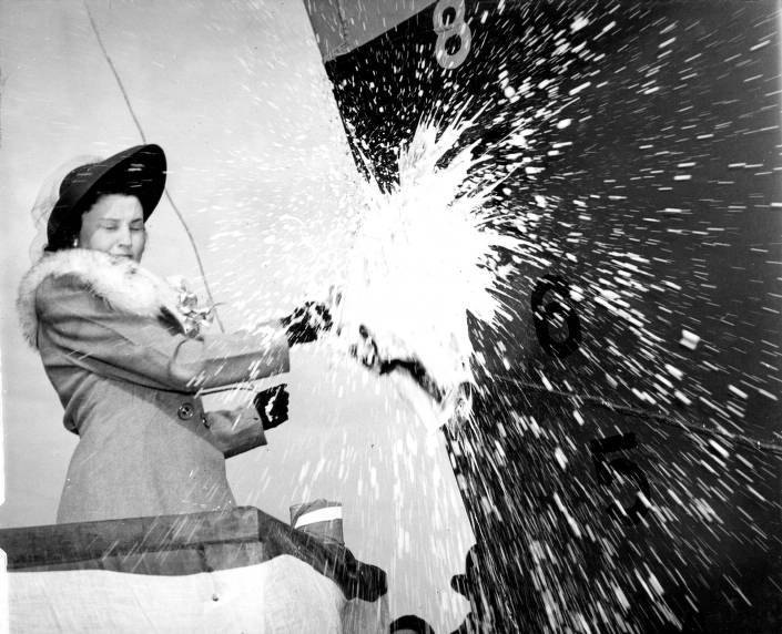 Florence Ratajczak smashes a bottle of champagne to christen a new ship, 1941-1946. Kewaunee Public Library.