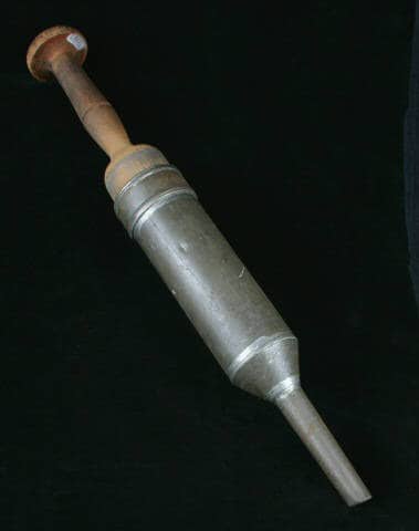 Sausage gun. Sausage was placed in the open end of the metal cylinder and the wooden plunger was used to force the sausage into a casing. Wisconsin Historical Museum.