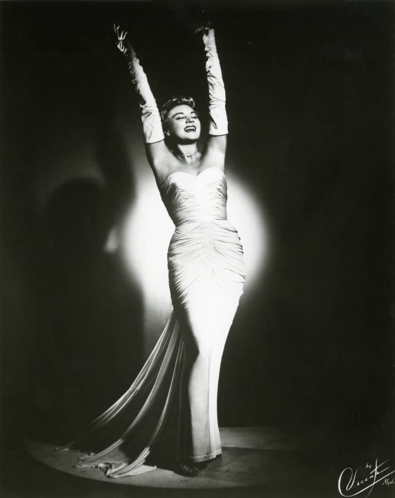 On February 1, 1906, cabaret singer Hildegarde Loretta Sell was born in Adell, Wisconsin. This publicity photo from the late 1950s shows Hildegarde in her trademark long white gloves; her arms are raised in her signature pose. In the Spotlight, Department of Special Collections and University Archives, Marquette University Libraries.