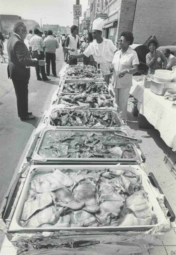 Food tables at Juneteenth Day festival, Milwaukee, 1983. Juneteenth, celebrated annually on June 19, commemorates the end of slavery in the United States.  Milwaukee Public Library.
