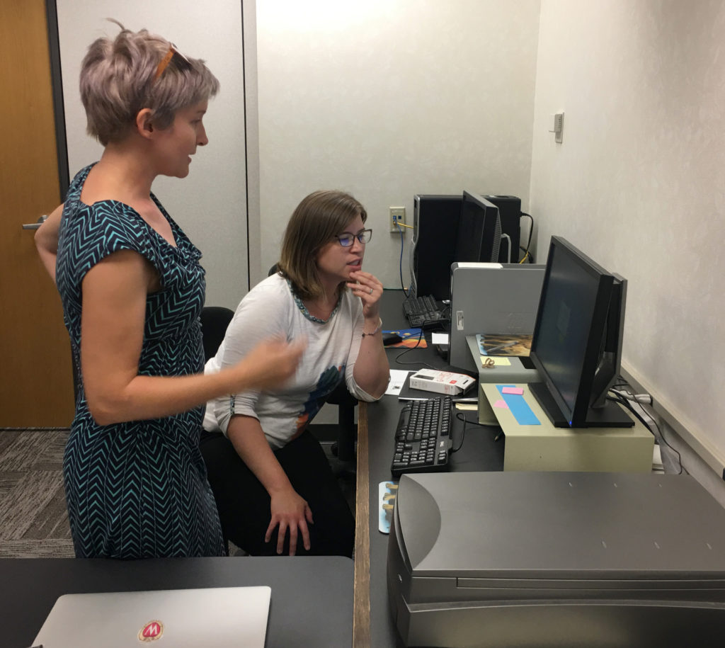 Mentor Jesse Henderson (University of Wisconsin Digital Collections Center) reviews procedures with  UW-Madison iSchool student Jessica Behrman at the La Crosse Public Library Archives.