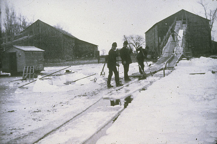 Workers float ice blocks harvested from Lake Winnebago to a warehouse to be packed and stored. Neenah Public Library/UWDCC.