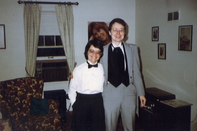 Mary O'Sullivan on the right and Francis Ball on the left posing together. They are dressed in tuxes at the 1983 Tux Party. 