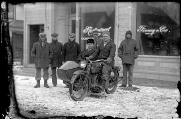 Eastman - Group of men and motorcycle in front of Finney & Co. Confectionary