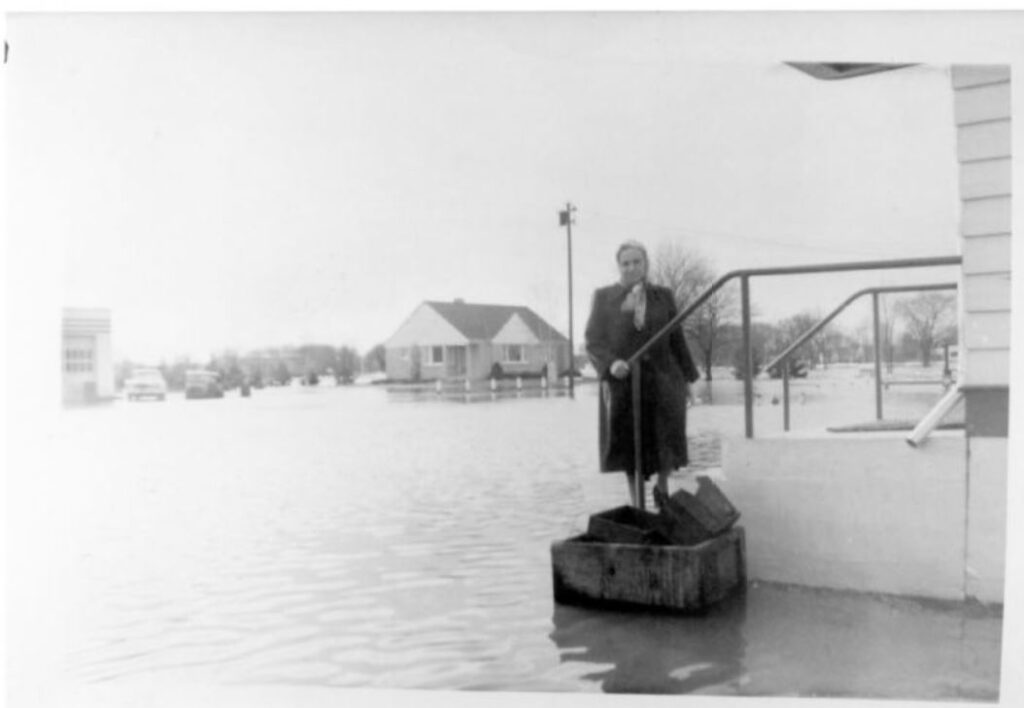 Woman standing on some steps during flooding of Saukville. Photographer unknown and photograph undated, but possibly 1959.