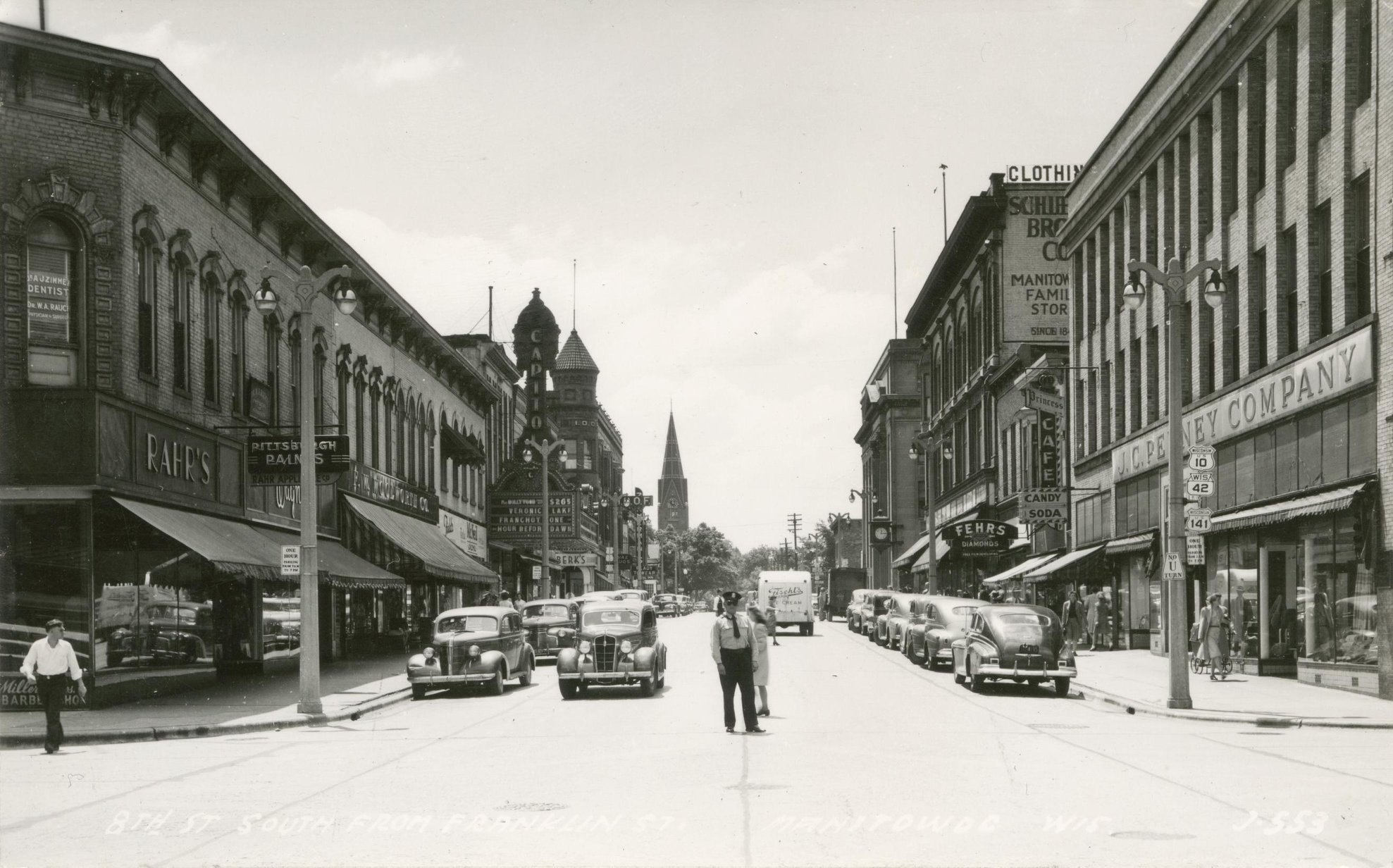 Black and white picture postcard showing a view of South 8th Street in Manitowoc, Wisconsin as the area appeared during the World War II years.