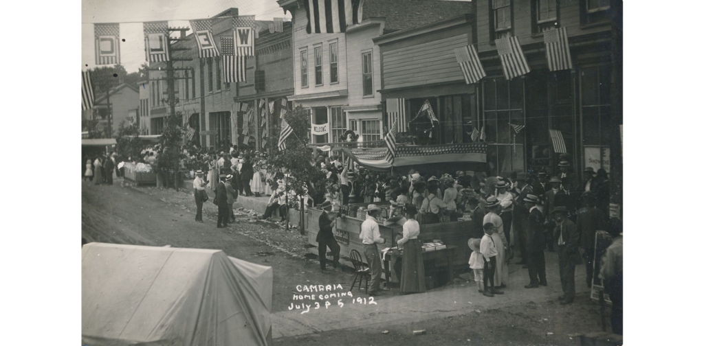 Homecoming, Cambria, Wis. postcard 1, 1912. People on main street.