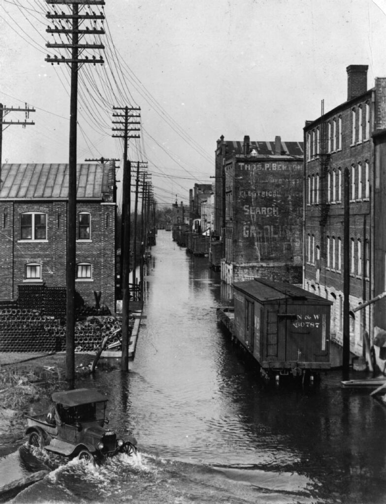 Image of Front Street downtown during a flood in 1920. La Crosse Plumbing Co. is pictured on the left. 