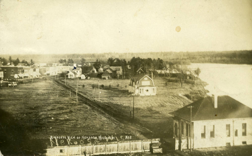 Shows the office building of Nekoosa Paper Company built around 1894. The building in the center of the photo is a mill owned house built for the mill manager. The area on left became part of the mill as it expanded. South Wood County Historical Corporation.