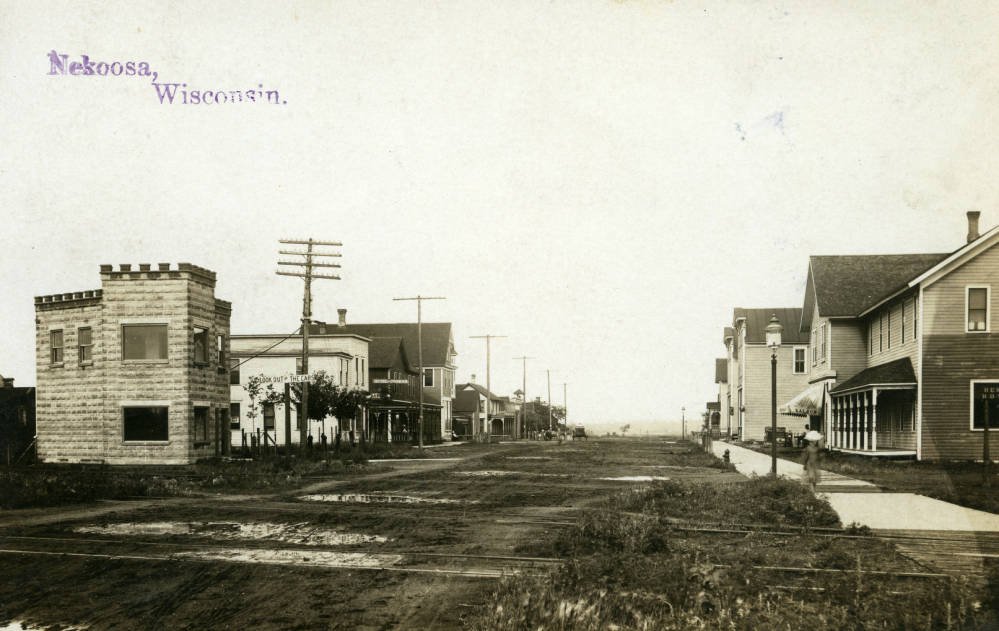 Main Street, Nekoosa. Building in foreground on left is Jim Misna's plumbing and appliance store. 1907. South Wood County Historical Corporation.