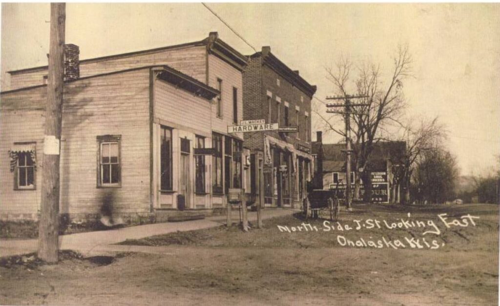 Reprinted postcard of Jay Street, now Main Street, prior to 1912. Post office, J.L. Mackey Hardware, Doctor Weston's office, and a confectionary are pictured.
