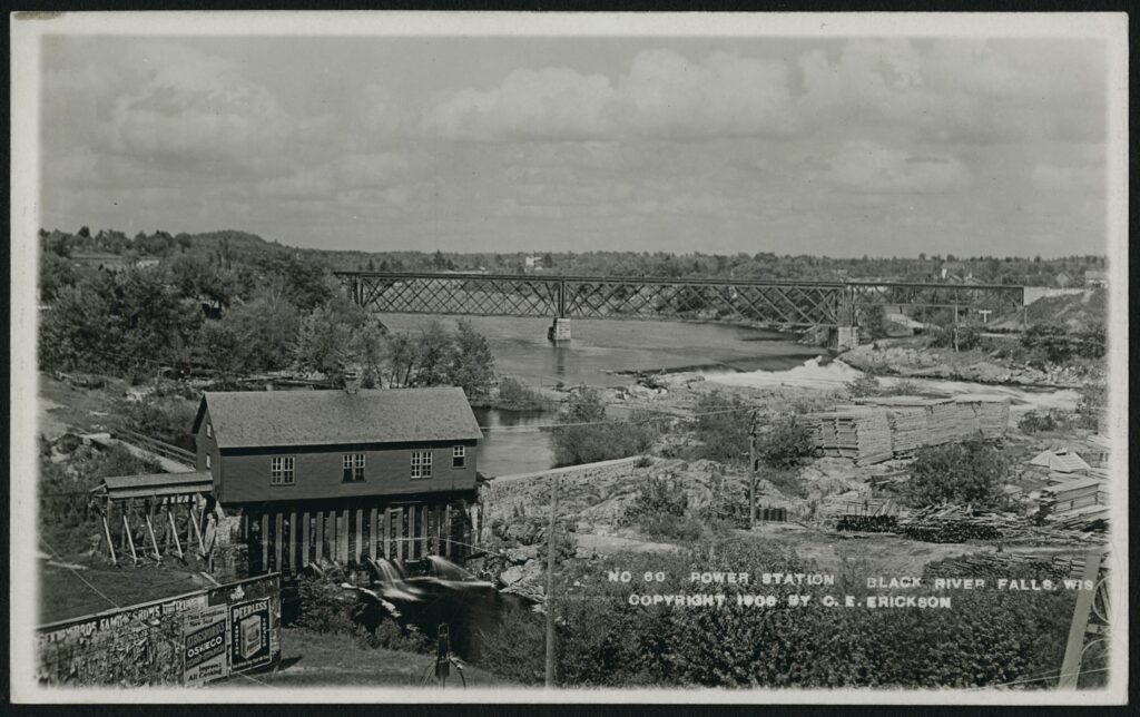 A postcard of a bridge over the river with the No. 60 power station in the foreground at Black River Falls, Wisconsin in 1908.