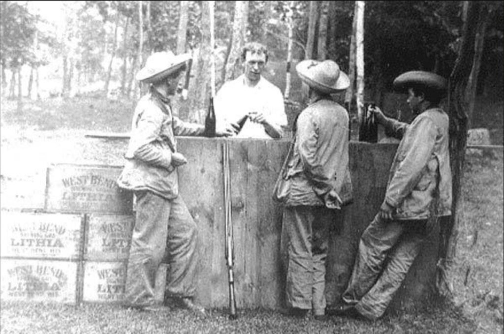 Fred Andre, Joe Eberle, Kirby Koch and Art Koch enjoy West Bend Lithia beer on tap in Northside Park, Kewaskum Wisconsin. 1900.