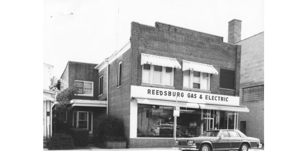 118 North Walnut St, Reedsburg, Sauk County, Wisconsin, 1983-1984. This commercial building was built prior to 1925. It was owned by Mrs. J. Dunning, who ran a dressmaking business here. It later housed Reedsburg Gas and Electric. [as of early 2024, this building is no longer standing.]