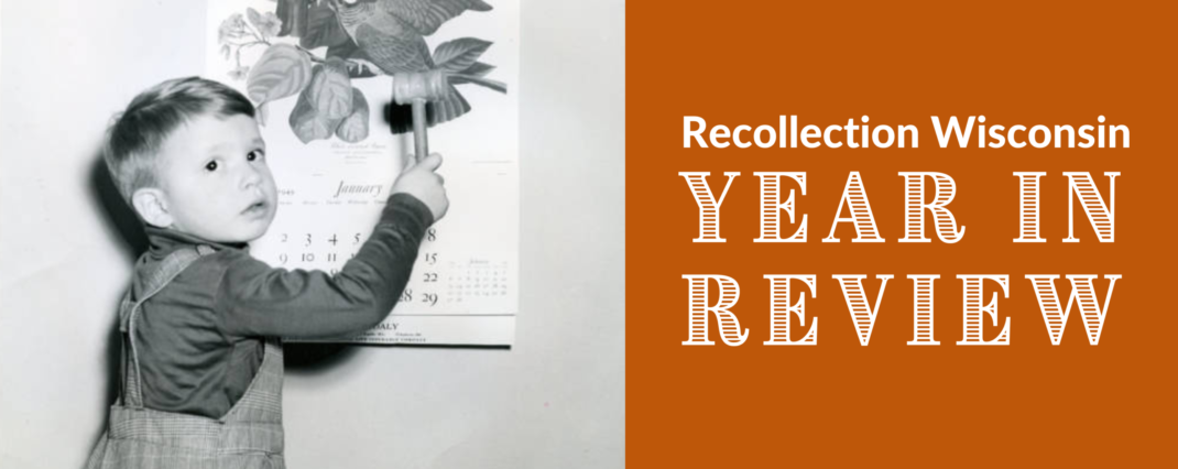 Boy with a calendar showing the end of 1949 and beginning of 1950 and words "Recollection Wisconsin Year in Review"
